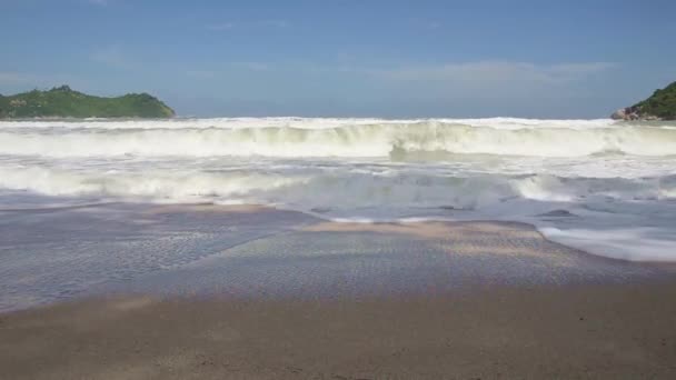 Hullámok összeomlik óvatosan homokos strandján, kamera tilt le. — Stock videók