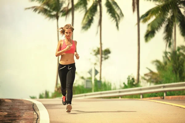 Young fitness woman running at tropical forest trail — Stock Photo, Image