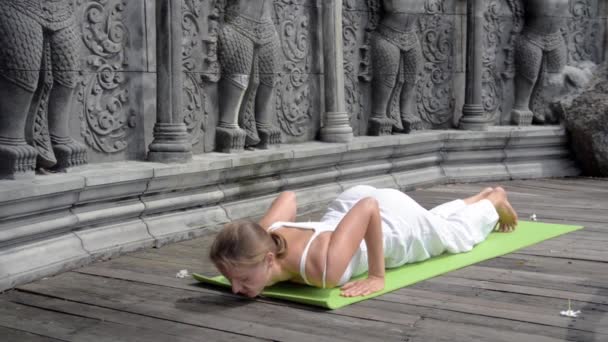 Vacker kvinna utövar yoga genom att göra övningar — Stockvideo