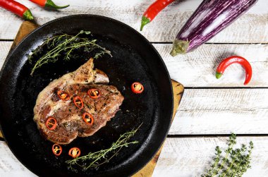 et ile bir tavada, biberiye ve Beyaz ahşap masa arka plan üzerinde sıcak biber baharat