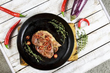 et ile bir tavada, biberiye ve Beyaz ahşap masa arka plan üzerinde sıcak biber baharat