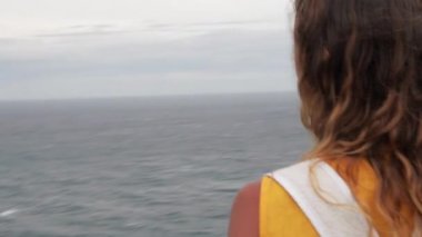 Uluwatu uçurumun kenarında duran ve fotoğraf çekmek kadın