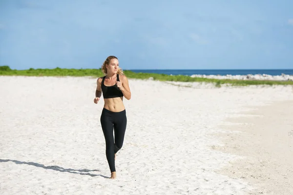 Young fitness woman running at beach — Stock Photo, Image