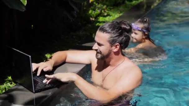 Счастливая молодая девушка и твой отец пользуются ноутбуком в бассейне — стоковое видео
