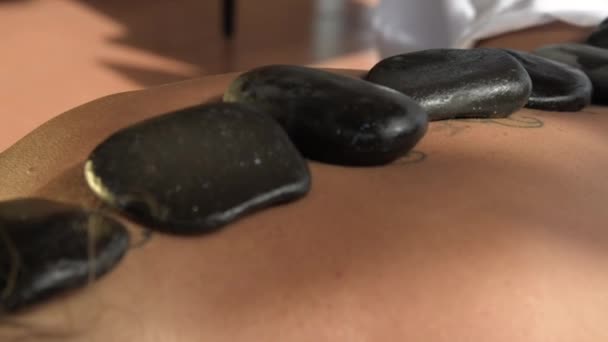 Paní u léčby při masáži. Čedičovými lávovými kameny s masážní oleje zacházení. HD — Stock video