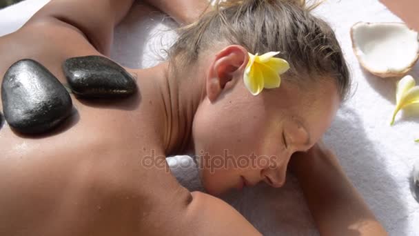 Woman getting hot stone massage in spa salon. — Stock Video