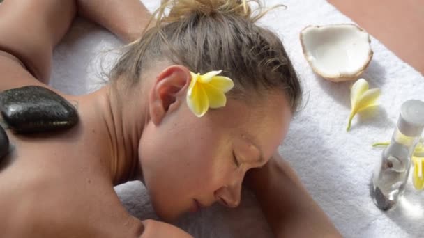 Kobieta zaczyna masaż gorącymi kamieniami w salonie spa. — Wideo stockowe
