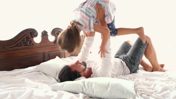 Happy Family Idyll Little Child Daughter Jump On Father Arms And They Fall On A Bed — Stock Video
