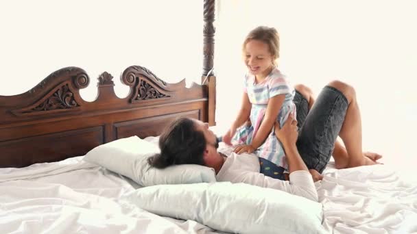 Happy Family Idyll Little Child Daughter Jump On Father Arms And They Fall On A Bed — Stock Video