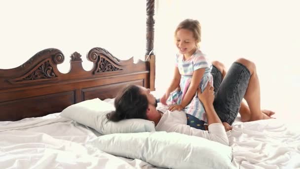 glückliches Familienidyll kleine Tochter springt Vater in die Arme und fällt auf ein Bett