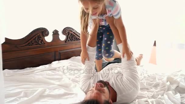 Ευτυχισμένος Idyll οικογένειας άλμα παιδί κοριτσάκι στην αγκαλιά του πατέρα και πέφτουν στο κρεβάτι — Αρχείο Βίντεο