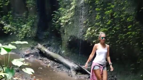 Caminhe até a cachoeira ao longo do caminho na floresta tropical. Bali. , — Vídeo de Stock