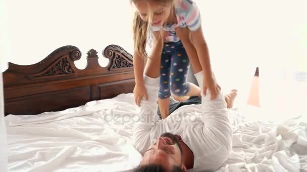 Happy Family Idyll Little Child Daughter Jump On Father Arms And They Fall On A Bed — Stock Video