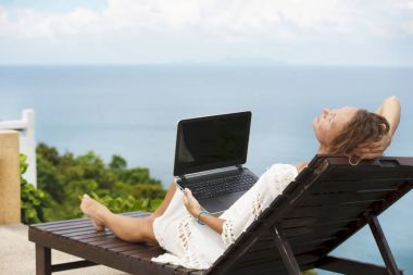 Kumsalda çalışıyorum. Online Internet açık havada dizüstü bilgisayar kullanan çalışma başarılı iş kadını.