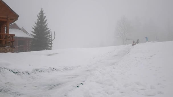Mutlu kız ve mather sürmek snowtube karlı yollarda — Stok video