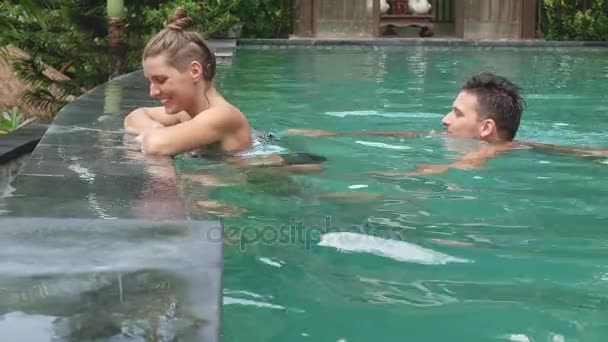 Привлекательная пара отдыхает у роскошного бассейна — стоковое видео