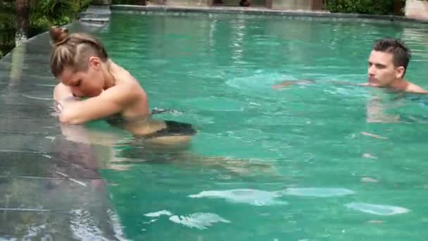 Casal atraente relaxante por piscina de luxo — Vídeo de Stock