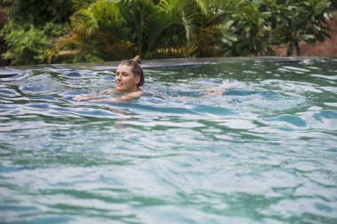 Mutlu genç kadın rahatlatıcı lüks Yüzme Havuzu tarafından