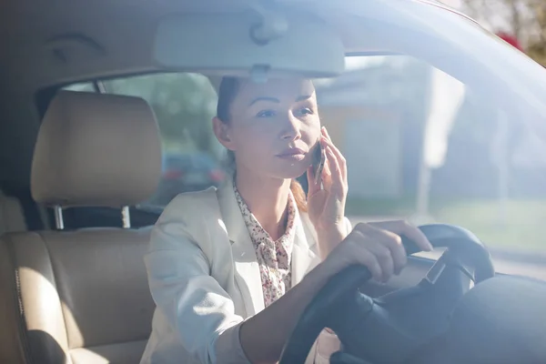 車の中で携帯電話を持つ女性. — ストック写真