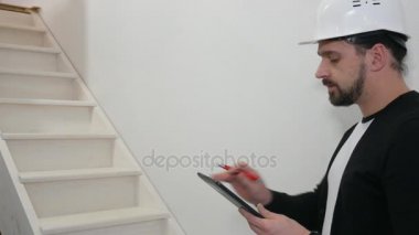 Baret inşaat sahasında tasarım çizimleri ile baş mimar. Alt proje sitesinde inşaat belgelerine ile