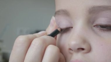 Anne kızı dudaklarından göz gölgeler uygulayarak