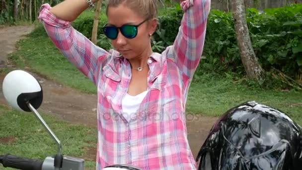 Junge Frau fährt Roller in tropischem Land — Stockvideo