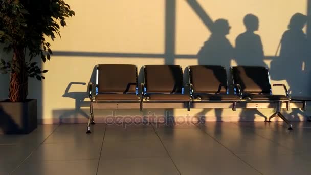 Vista trasera de los pasajeros caminando y llevando una maleta en un aeropuerto — Vídeos de Stock