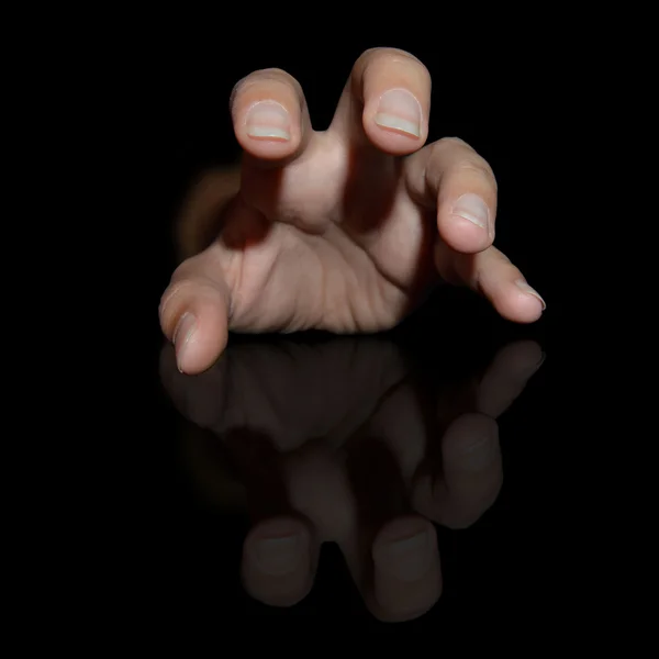 Suffering hand on a black background — Stock Photo, Image