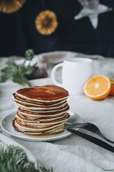 Akçaağaç syrop ve şeker tozu ile bir fincan sade kahve ve portakal tepesinde geleneksel Amerikan krep içeren kahvaltı sahnenin bir natürmort