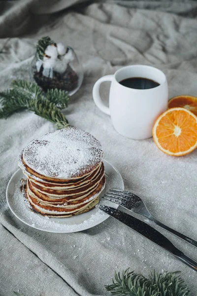 Akçaağaç syrop ve şeker tozu ile bir fincan sade kahve ve portakal tepesinde geleneksel Amerikan krep içeren kahvaltı sahnenin bir natürmort