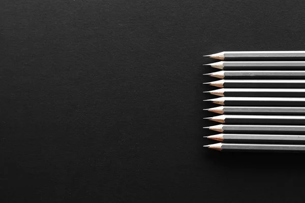 Onbir gri kalem yatay metin için bazı ücretsiz boş yer siyah bir zemin sağ tarafında yer