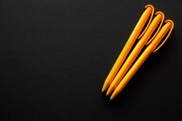 Bazı ücretsiz boş yer için metin ile siyah bir zemin üzerinde yerleştirilen üç sarı kalemler