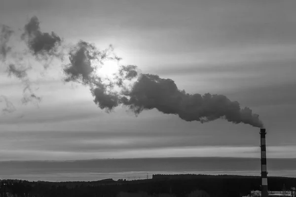Gün doğumu endüstriyel görünüm şehir içinde. Tepeler haddeleme tarafından bir otoyol geçti ve bir beyaz ve kırmızı çizgili boru ile ısıtma tesisi eşliğinde.