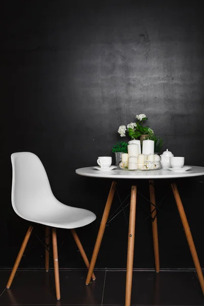 Beyaz bir sehpa beyaz bardak ve çay potu, beyaz mumlar, bazı yeşil çim ve çiçek ile. Beyaz bir sandalye eşlik etti. çatı tasarım