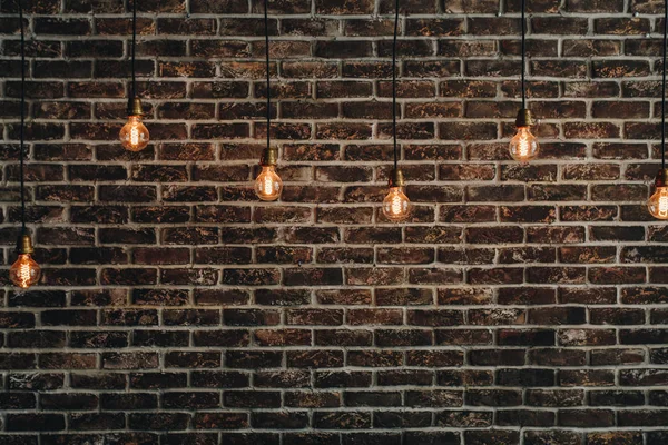 Vintage ampuller teller üzerinde asılı bir arka plan bir kırmızı tuğla duvar