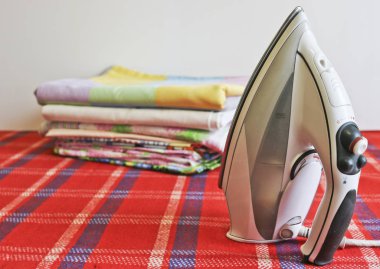 Modern demir ve ütülenmiş keten yığını. Ev işleri..