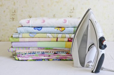 Modern demir ve ütülenmiş keten yığını. Ev işleri..