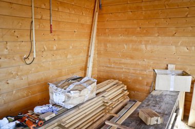 Bir kır evinin inşaat ve dekorasyon süreci, iç görünüş. Ahşap duvar kaplaması, yerde inşaat malzemeleri..