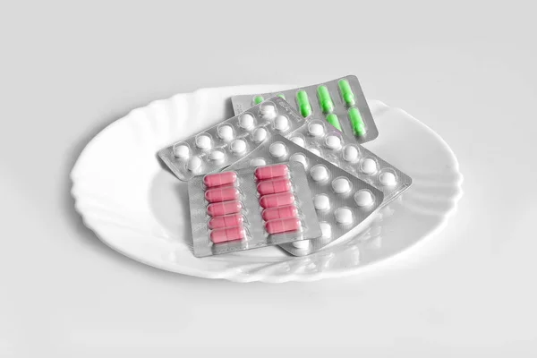 Comprimidos diferentes num prato. O conceito de medicamentos de prescrição fo — Fotografia de Stock