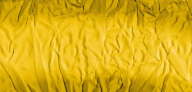 Buruşuk kumaşın canlı sarı dokusu. Doğal kıvrımlı sarı tekstil. Yakın plan.