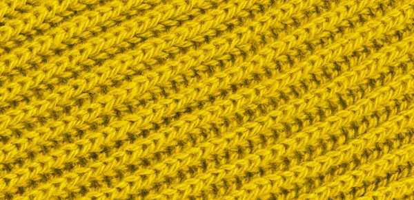 Vibrant yellow texture knitted wool scarf. Yellow textile background knitwear. Close-up