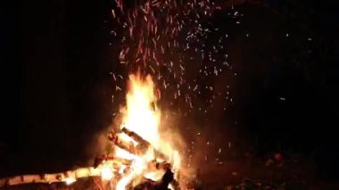 Geceleri ormanda, nehrin kenarında şenlik ateşi. Bir adam ateşe sopa vurur, kıvılcımlar saçar..