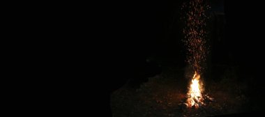 Geceleri ormanda, nehrin kenarında şenlik ateşi. Romantik bir akşam. Kopyalama alanı ile