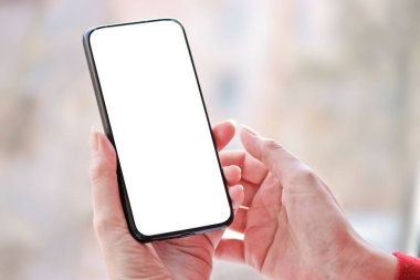 Akıllı telefonlu kadın eli, kopyalama alanı olan beyaz boş ekran.