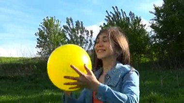 Yaz Park sarı bir top ile oynayan genç kız. Video görüntüleri Hd.