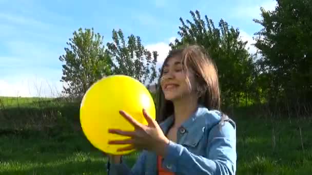 Teenager-Mädchen beim Spielen mit einem gelben Ball im Sommerpark. Videoaufnahmen. — Stockvideo