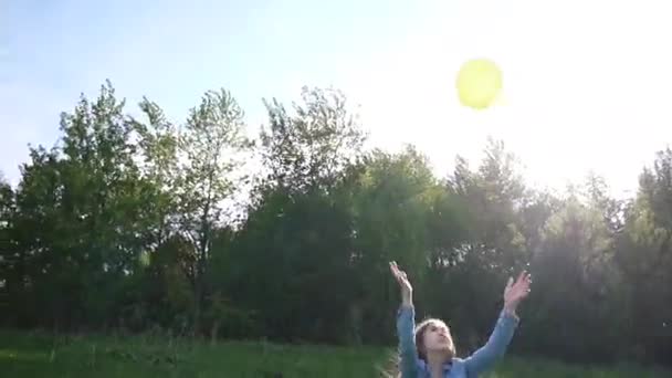 Teenager-Mädchen beim Spielen mit einem gelben Ball im Sommerpark. Videoaufnahmen. — Stockvideo