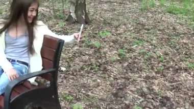 Selfie fotoğraf smartphone, yaz aylarında Parkı'nda alarak loseup alarak kız. Poz ve gülümseyerek. Video çekim hareket kamera steadicam ile.