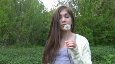 Genç kız bir karahindiba üzerinde üfleme. Video görüntüleri Hd statik kamera çekim..