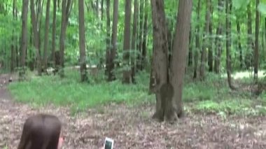 Selfie fotoğraf smartphone Parkı'nda yaz aylarında alarak kız. Poz ve gülümseyerek. Video çekim hareket kamera steadicam ile.